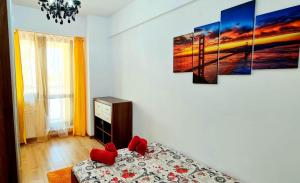 a bedroom with a bed with red pillows on it at Designed like Home Apartment near Palas Mall in Iaşi