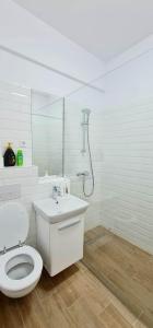 a white bathroom with a toilet and a shower at Designed like Home Apartment near Palas Mall in Iaşi