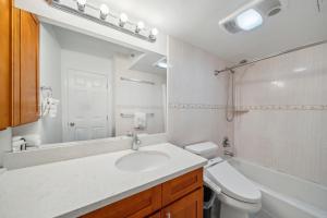 y baño con lavabo, aseo y espejo. en 23rd Floor Waikiki Banyan Condo - Only One Block from Beach! condo en Honolulu