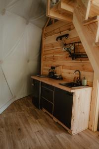 a kitchen with a sink and a stove at Czarna Hańcza Glamping in Głęboki Bród