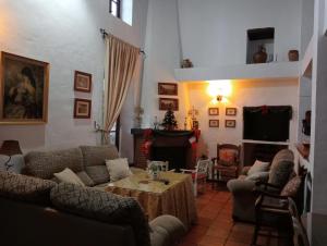 a living room with couches and a table and a fireplace at Casa Rural La Maquinilla in Grazalema