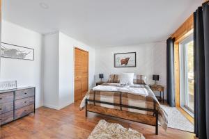 1 dormitorio con 1 cama, vestidor y ventana en Chalet bord de l'eau et sentier, en Mont-Laurier