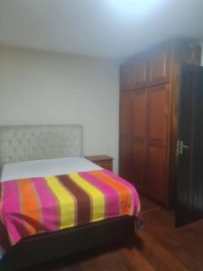 a bedroom with a bed with a colorful striped blanket at Casa em Torres in Torres