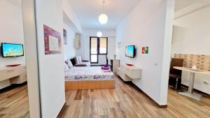 um quarto com uma cama, uma secretária e uma televisão em Karina New Flat near Palas Mall em Iaşi