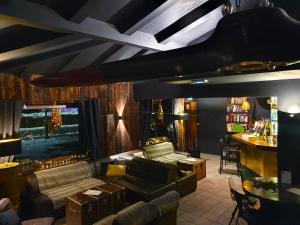 a living room with a couch and a tv at Chalet Hôtel du Bois in Les Houches
