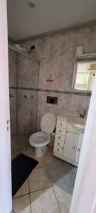 a bathroom with a toilet and a shower and a sink at Suítes Praia Do Foguete in Cabo Frio