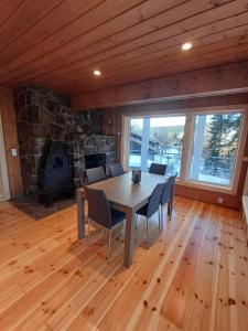 a dining room with a table and a stone fireplace at K8 Apartment in Kongsberg