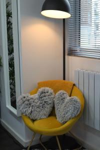 a yellow chair with furry pillows on it at Crescent Apartment in Eastbourne