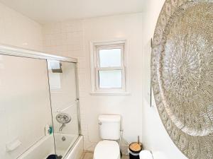 a bathroom with a toilet and a shower and a mirror at Family-Friendly 2BR in Quiet Area -AM1 in Los Angeles