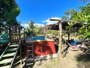 a small shack with a pool and a hammock at Casa Tili TicoExperience on IslaDamas in Quepos