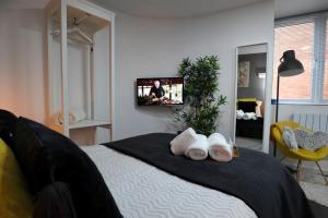 a bedroom with a bed with a tv on the wall at Crescent Apartment in Eastbourne