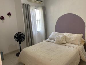 a bedroom with a bed with white sheets and a window at Casa Orizaba in Ciudad Valles