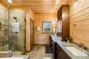 Un baño con ducha de cristal y lavabo. en Sugar Bear, en Sevierville 34 fotos más