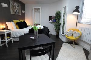 ein Wohnzimmer mit einem Bett und einem Tisch mit einer Vase in der Unterkunft Crescent Apartment in Eastbourne