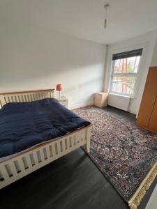 a bedroom with a bed and a rug and a window at Silk Accommodation in Margate