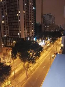 eine Stadtstraße in der Nacht mit Bäumen und Gebäuden in der Unterkunft Mini departamento lujo in Lima