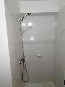 um chuveiro branco com uma mangueira na casa de banho em Mini departamento lujo em Lima