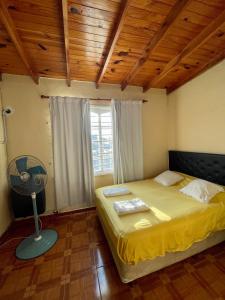 Un dormitorio con una cama con ventilador y una ventana. en Urquiza 579, en Concepción del Uruguay