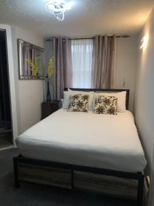 1 dormitorio con 1 cama grande con sábanas y almohadas blancas en Relax Inn Guest House, en Brighton & Hove