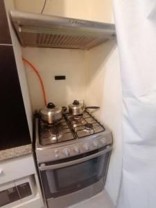 a small stove with two pots on top of it at Mini departamento lujo in Lima +10 photos