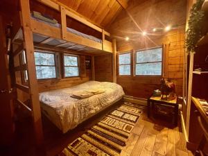 een slaapkamer met een bed in een houten hut bij Spectacular Seven Keys Camp on Pristine Loon Lake 