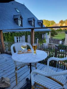 a table with two glasses of wine on a deck at LA MAISON 1788 in Meymac