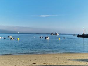 a group of boats in the water near a beach at Apartamento Raxobrisamar in Raxo