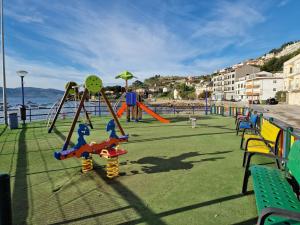 un parco giochi con altalene e scivolo sulla spiaggia di Apartamento Raxobrisamar a Raxó
