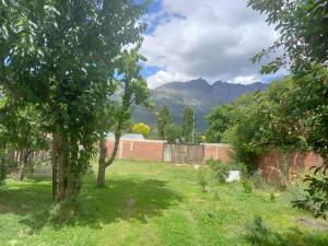 a garden with trees and mountains in the background at Dos Soles in El Bolsón