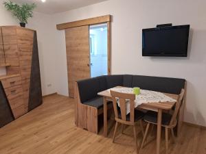 Ferienwohnung Abenthung في Grinzens: غرفة معيشة مع طاولة وتلفزيون