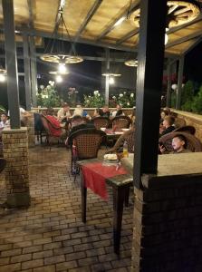 een patio met mensen aan tafel in een restaurant bij Fantastik Ayaz Apartments in Ohrid