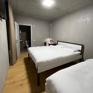 a bedroom with two beds and a hallway with at ИксаОтель in Shymkent