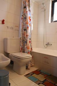 uma casa de banho com um WC e uma cortina de chuveiro em Nafplion Seaside em Néa Kíos
