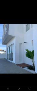 un edificio bianco con una palma di fronte di PIPA Magnifique villa moderne en front de mer a Tibau do Sul