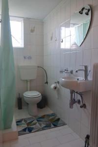 uma casa de banho com um WC, um lavatório e um espelho. em Nafplion Seaside em Néa Kíos