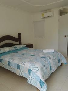 a bedroom with a bed with a blue and white comforter at Hotel parador tropical in Cartagena de Indias
