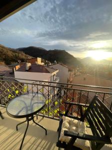 a glass table and chair on a balcony with a view at Prizren Apartment's in Prizren