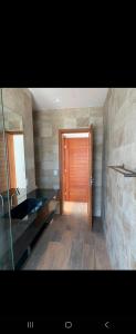 a bathroom with a wooden door and a mirror at PIPA Magnifique villa moderne en front de mer in Tibau do Sul