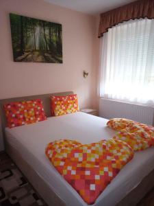 1 dormitorio con 1 cama grande y almohadas coloridas en Holiday home Balatonfűzfo/Balaton 18797 en Balatonfůzfő