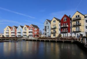 una fila de casas coloridas junto a un río en Am Altstadt - Yachthafen, en Greifswald