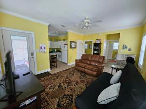 a living room with a couch and a kitchen at Perdido Key Purple Parrot Resort in Perdido Key