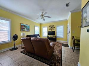 a living room with a couch and a television at Perdido Key Purple Parrot Resort in Perdido Key