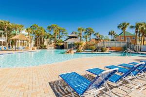 a swimming pool with blue lounge chairs in a resort at Perdido Key Purple Parrot Resort in Perdido Key