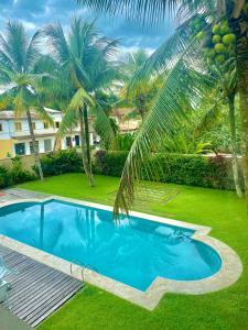 - une piscine dans une cour avec des palmiers dans l'établissement Casarão Caborê, à Parati