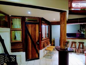 Habitación con puerta de madera, mesa y sillas en Se Ua en Manzanillo