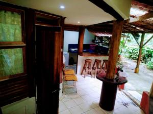 uma cozinha com um balcão e bancos num quarto em Se Ua em Manzanillo