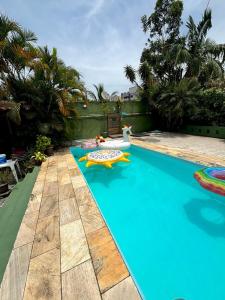 a large blue swimming pool with a float on it at Casa Jambo Hostel Para Mulheres in Guarujá