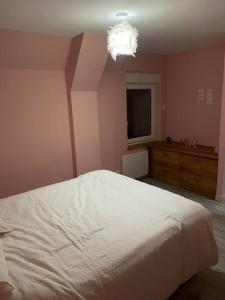 ein Schlafzimmer mit einem weißen Bett und einer Kommode in der Unterkunft Gîte le refuge des Hiboux in Saint-Pierre-sur-Dives
