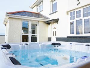 a hot tub in front of a house at Pass the Keys Breathtaking holiday home packed with amenities in Borth