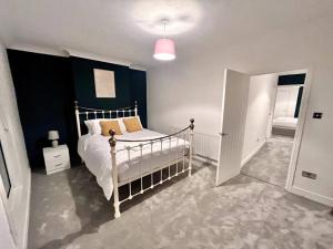 a bedroom with a white bed and a blue wall at Modern Mountain Retreat in the Brecon Beacons in Ystradgynlais